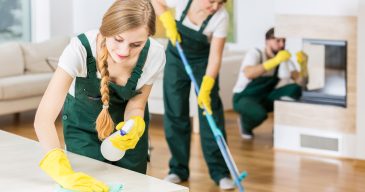 Group of friends as a professional cleaners tiding up big apartment